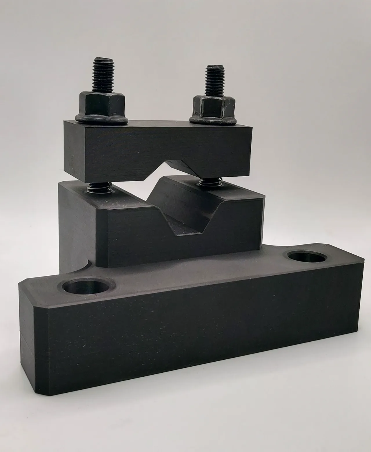 Black anodized aluminum shaft workholding fixture with clamping jaws and bolts
